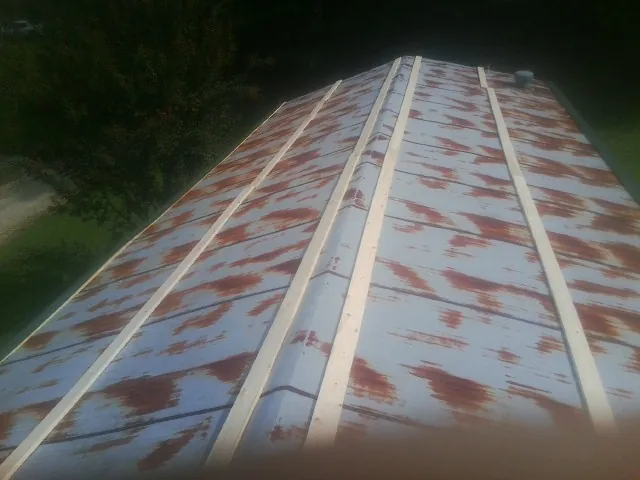 Rusted metal roof panels with new wood purlins before replacement — Storm Damage Roof Repair in Nerstrand by Roofing Brothers