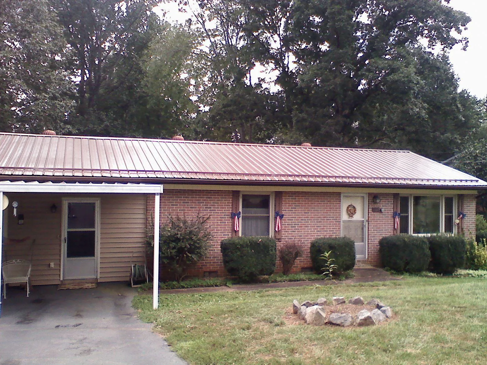 Bronze metal roof and carport on a brick ranch home — Roof Repair work by our crew in Nerstrand